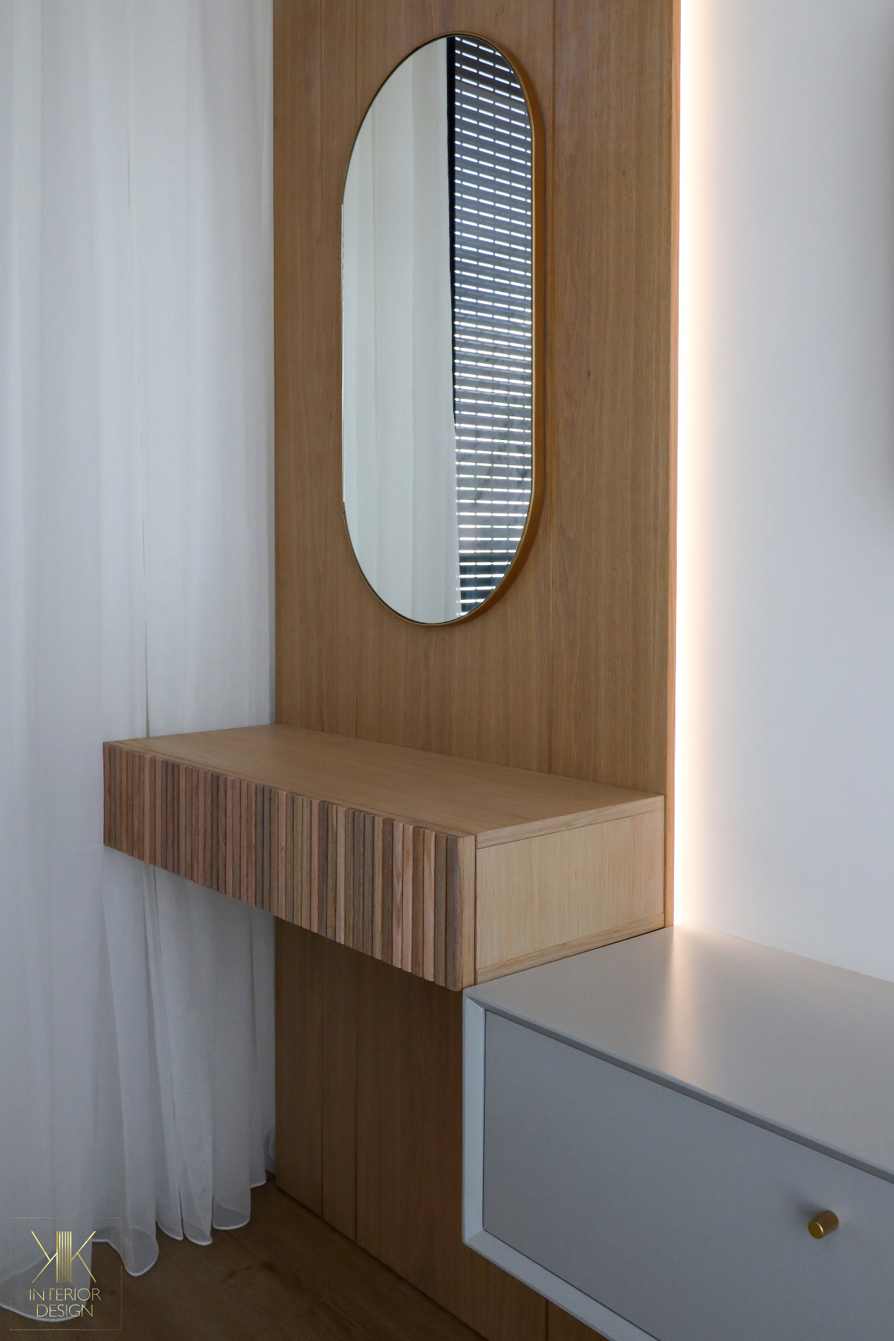 Floating oak vanity with fluted drawer front and oval mirror