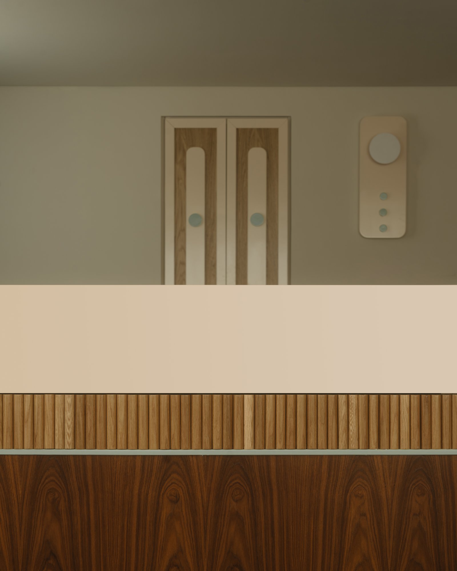 Close-up of walnut and fluted oak reception with joinery detail