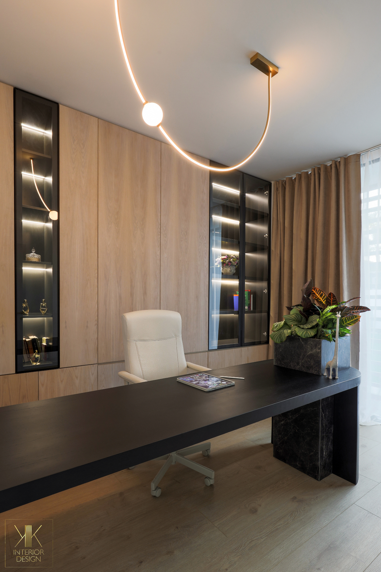 Home office with black desk and full-height oak cabinetry